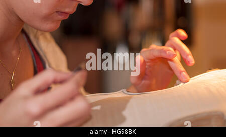 a Woman, Master Luthier at work in his laboratory in Cremona, Italy Stock Photo