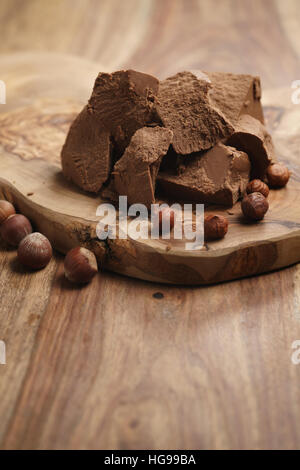 chunks of gianduja with hazelnuts on wood board Stock Photo
