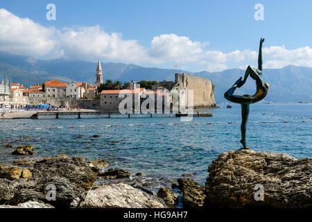 Dancing girl statue with Budva Old Town in the background Stock Photo