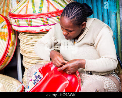 Ethiopian woman makes Habesha baskets for sale on a local market in Addis Abeba. Stock Photo