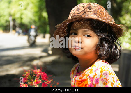 Close-up of little Indian girl wearing hat posing for camera Stock Photo