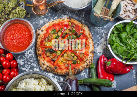 Traditional vegetarian italian pizza with pumpkin eggplant, peppers and tomato sauce on black chalkboard Stock Photo