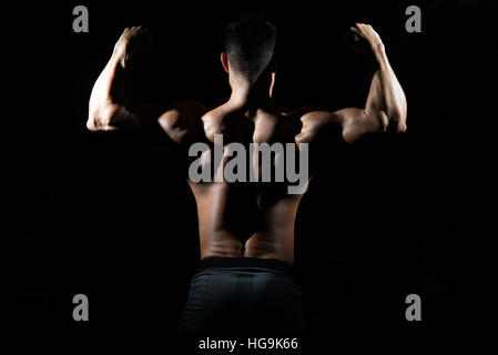 Silhouette Healthy Man Standing Strong In The Gym And Flexing Muscles - Muscular Athletic Bodybuilder Fitness Model Posing After Exercises Stock Photo