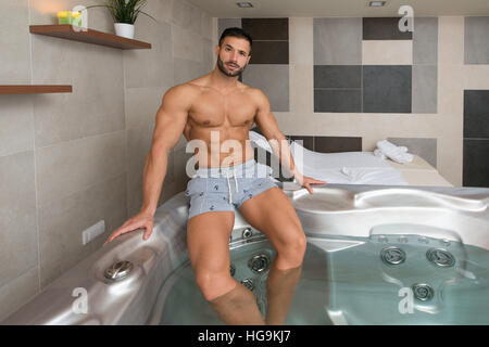 Wellness Spa - Man Relaxing in Hot Tub Whirlpool Jacuzzi Indoors at Luxury Resort Spa Retreat - Handsome Young Male Model Relaxed Resting in Water Nea Stock Photo