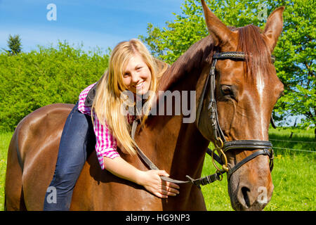 Young, happy woman riding her horse Stock Photo
