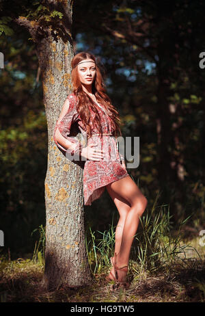 Portrait of a beautiful young hippie girl standing near the tree Stock Photo