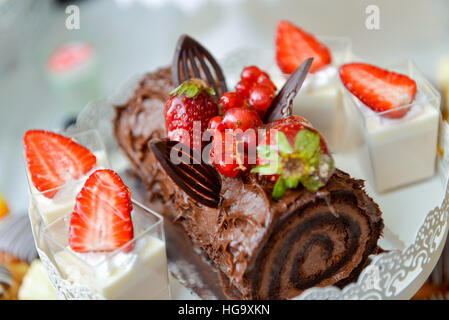 Chocolate roulade with strawberries on the table Stock Photo
