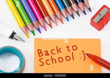 School supplies and inscription on orange sticky - back to school Stock Photo