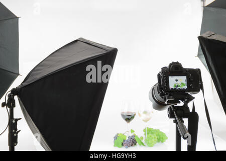 Professional SLR camera on a tripod takes a shot in the studio. Stock Photo