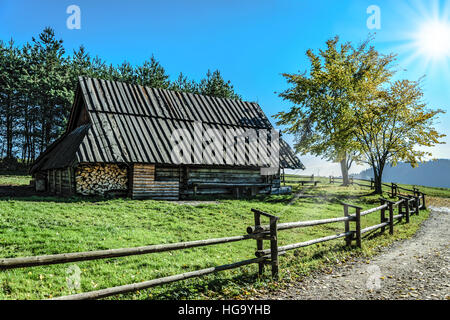 Old wooden hut in the mountains on a sunny day Stock Photo