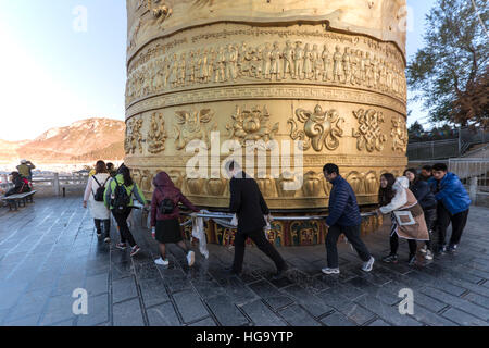 Shangri-La, China - November 12, 2016: Tousits spinning the world's biggest Prayer Wheel in Shangri-La Golden Temple Stock Photo