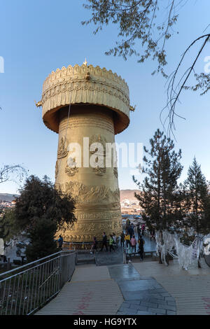 Shangri-La, China - November 12, 2016: Tousits spinning the world's biggest Prayer Wheel in Shangri-La Golden Temple Stock Photo