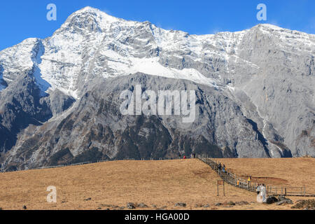 Lijiang, China - ovember 11,2016: Panoramic view of the Jade Dragon Snow Mountain in Yunnan, China and tourists walking on the path Stock Photo