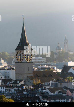 Clock tower of Zurich's St. Peter church and church Enge (also called 'Sacre Coeur of Zurich') in the background. Stock Photo