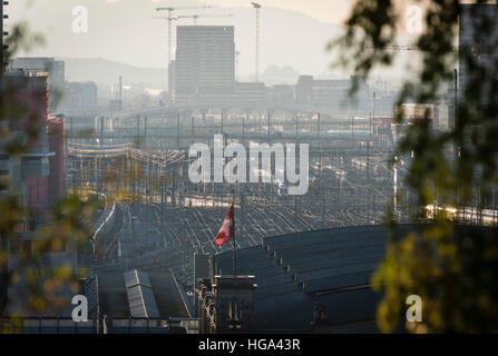 The Swiss flag is flying in the sunset on top of Zurich main station, one of Europe's busiest railway stations. Stock Photo