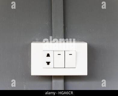 Plastic electrical socket with lighting switch on the house wall. Stock Photo