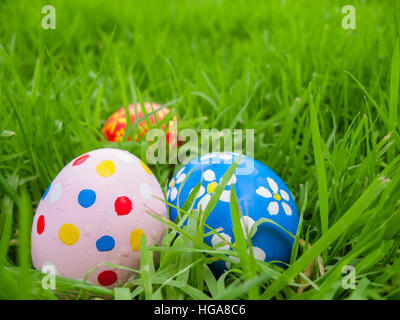 Easter eggs hidden in the grass for the hunt /// lawn egg hiding green meadow hide park outdoors decorated holiday spring colorful celebration game Stock Photo