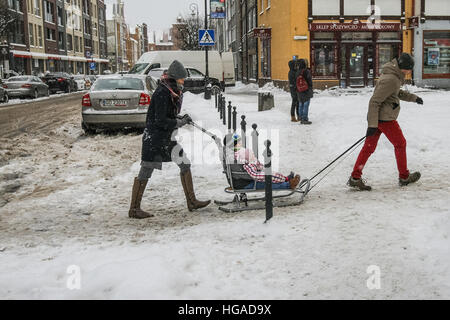 Gdansk, Poland. 6th Jan, 2017. People with child on the sledge are seen. Heavy snow fall, and frost hits northern Poland city of Gdansk. Low temperature close to minus 10 Celsius degrees and snow paralyzes road traffic in the region. © Michal Fludra/Alamy Live News Stock Photo