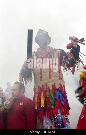 Haxey, Lincolnshire, UK. 6th Jan, 2017. The Haxey Hood is a 700-year old game, it took place today during a downpour. The Haxey fool is paraded around three pubs, singing chants and drinking free ale, burning of straw near village church behind the fool, then men and children do battle on a near by field.Smoking of the fool. © Ian Francis/Alamy Live News Stock Photo