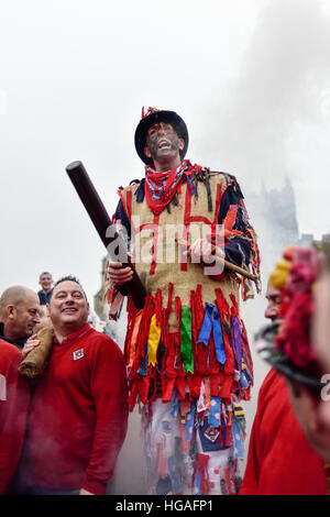 Haxey, Lincolnshire, UK. 6th Jan, 2017. The Haxey Hood is a 700-year old game, it took place today during a downpour. The Haxey fool is paraded around three pubs, singing chants and drinking free ale, burning of straw near village church behind the fool, then men and children do battle on a near by field.Smoking of the fool. © Ian Francis/Alamy Live News Stock Photo