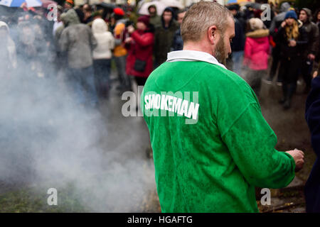 Haxey, Lincolnshire, UK. 6th Jan, 2017. The Haxey Hood is a 700-year old game, it took place today during a downpour. The Haxey fool is paraded around three pubs, singing chants and drinking free ale, burning of straw near village church behind the fool, then men and children do battle on a near by field.The Smokeman. © Ian Francis/Alamy Live News Stock Photo