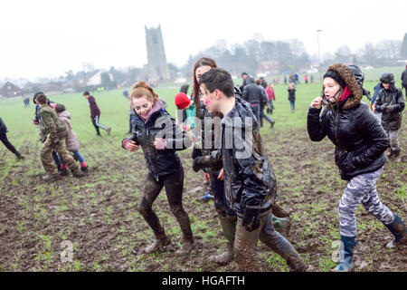 Haxey, Lincolnshire, UK. 6th Jan, 2017. The Haxey Hood is a 700-year old game, it took place today during a downpour. The Haxey fool is paraded around three pubs, singing chants and drinking free ale, burning of straw near village church behind the fool, then men and children do battle on a near by field. © Ian Francis/Alamy Live News Stock Photo