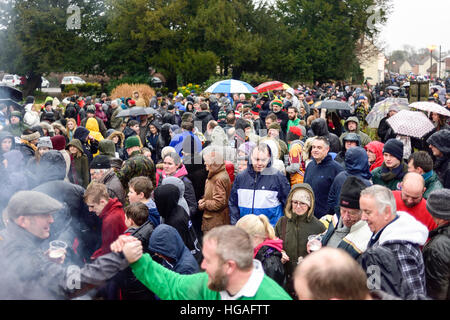 Haxey, Lincolnshire, UK. 6th Jan, 2017. The Haxey Hood is a 700-year old game, it took place today during a downpour. The Haxey fool is paraded around three pubs, singing chants and drinking free ale, burning of straw near village church behind the fool, then men and children do battle on a near by field. © Ian Francis/Alamy Live News Stock Photo