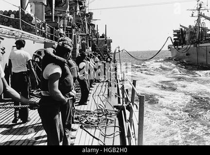 Line handlers aboard USS Boston bring across a fuel hose from USS Camden, Vietnam War, 1968. Stock Photo