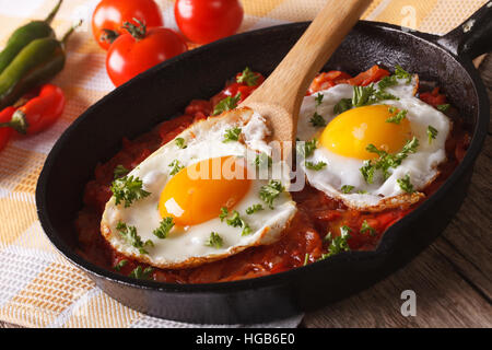 Mexican breakfast huevos rancheros: fried egg with salsa closeup in the pan. Horizontal Stock Photo