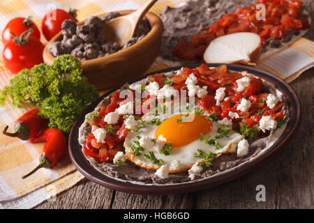 Mexican fried eggs huevos rancheros and ingredients close-up on the table. Horizontal Stock Photo