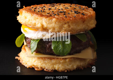 Trendy ramen burger with beef and eggs macro on a black background Stock Photo