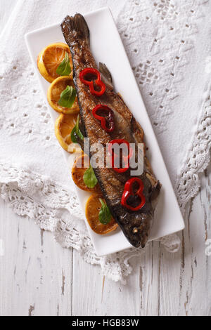 grilled rainbow trout with vegetables on a plate on the table. vertical top view Stock Photo