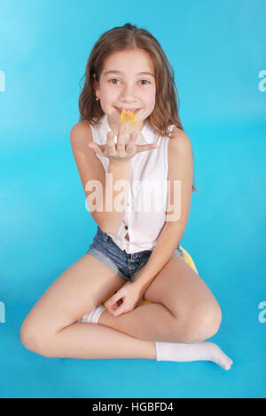Young girl playing with chewing gum isolated on blue Stock Photo