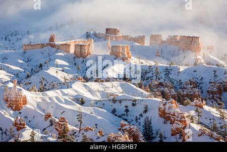 A ridge of hoodoos covered in snow about to be swallowed by the fog in Bryce Canyon National Park, Utah Stock Photo