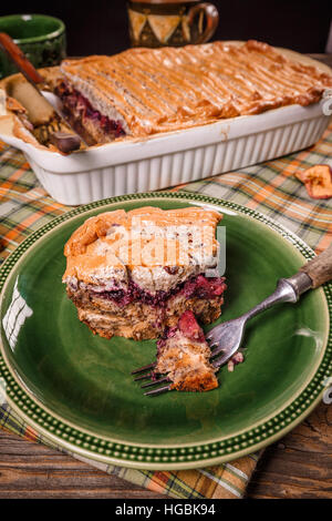 Fresh-baked English bread pudding with apple in baking dish on the table. Stock Photo