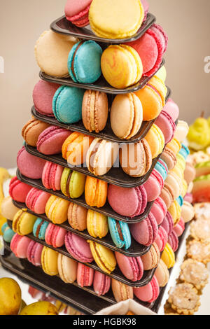 Colorful macarons on pyramid-shaped tower stand as part of candy bar sweet table Stock Photo