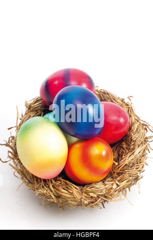 Easter nest filled with coloured eggs Stock Photo