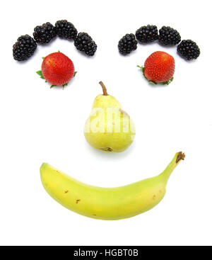 Happy smiling fruit face. Kid friendly. Eat your fruits. Banana, pear, strawberry, and blackberry. Stock Photo