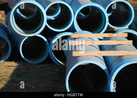 Stacked blue water pipes at a construction site. Stock Photo