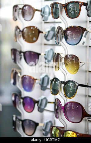 Colorful and different sunglasses on a stand in the shop Stock Photo