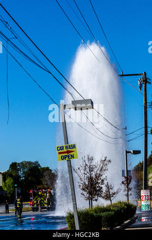 A fire hydrant broken off by a truck creates a geyser and small flood in San Leandro California Stock Photo