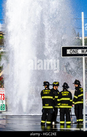 A fire hydrant broken off by a truck creates a geyser and small flood in San Leandro California Stock Photo