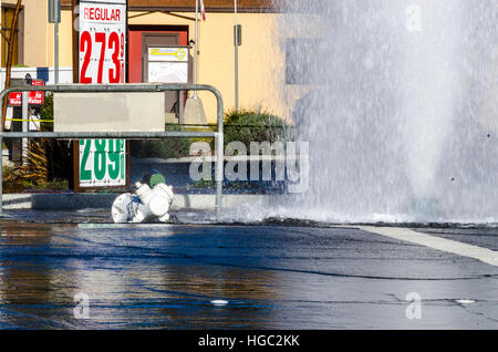 A fire hydrant broken off by a truck creates a geyser and small flood in San Leandro California Stock Photo