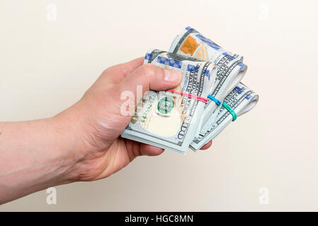 Male hand holding packs of one hundred dollar banknotes Stock Photo