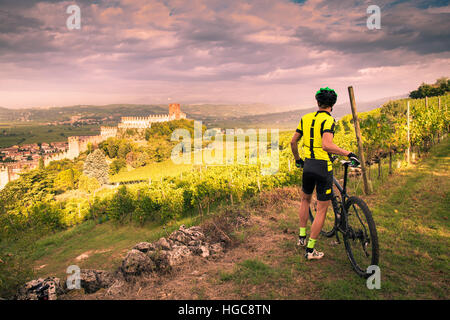 Cyclist admires from the hill the Soave castle views. Stock Photo