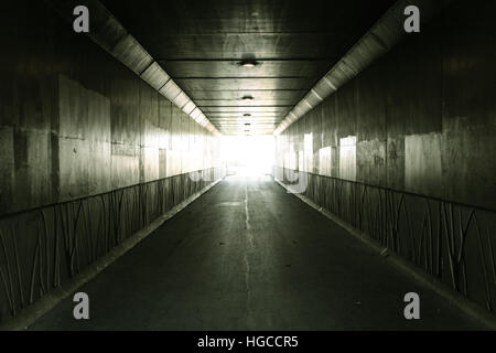 Light At The End Of The Tunnel Pedestrian tunnel illuminated by bright sunlight at the exit Stock Photo