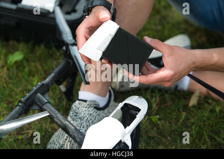 Closeup of Young Engineer Man Checking the Battery of Uav Drone With Hand Tool in Park Stock Photo
