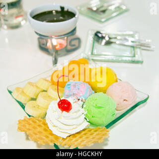 Low fat homemade Ice-cream with berry, whip cream served with sliced banana, waffle and chocolate fongdu, a very famous sweet dessert in Thailand Stock Photo