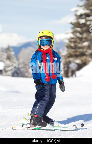 Cute little boy, skiing happily in Austrian ski resort in the mountains, wintertime Stock Photo