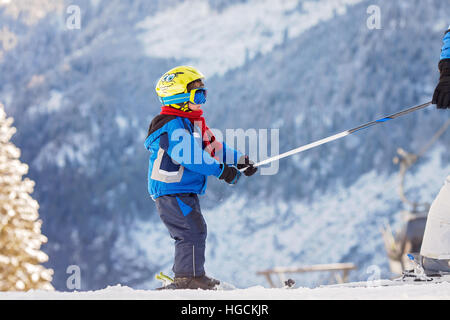 Cute little boy, skiing happily in Austrian ski resort in the mountains, wintertime Stock Photo